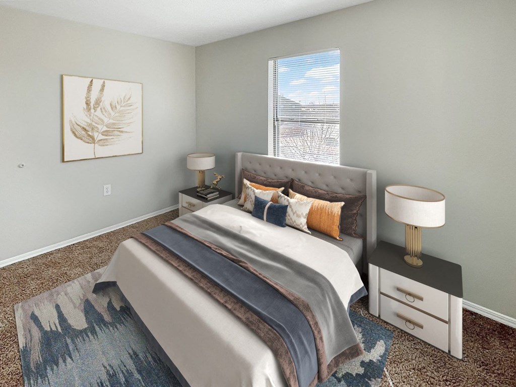 A bedroom with a large bed, a nightstand with a lamp, and a framed picture on the wall.